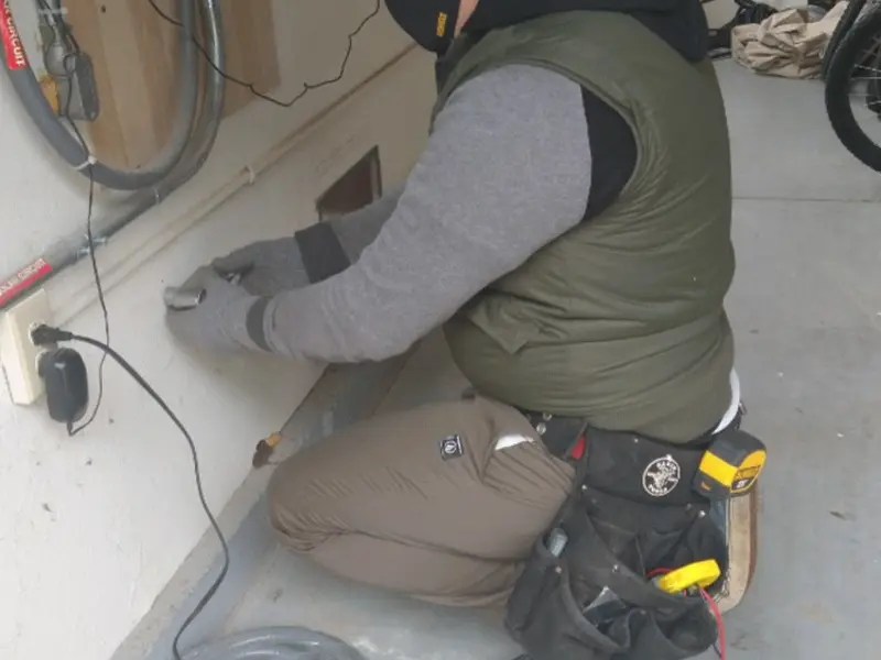 Electrician performing outlet wiring in a De Soto garage